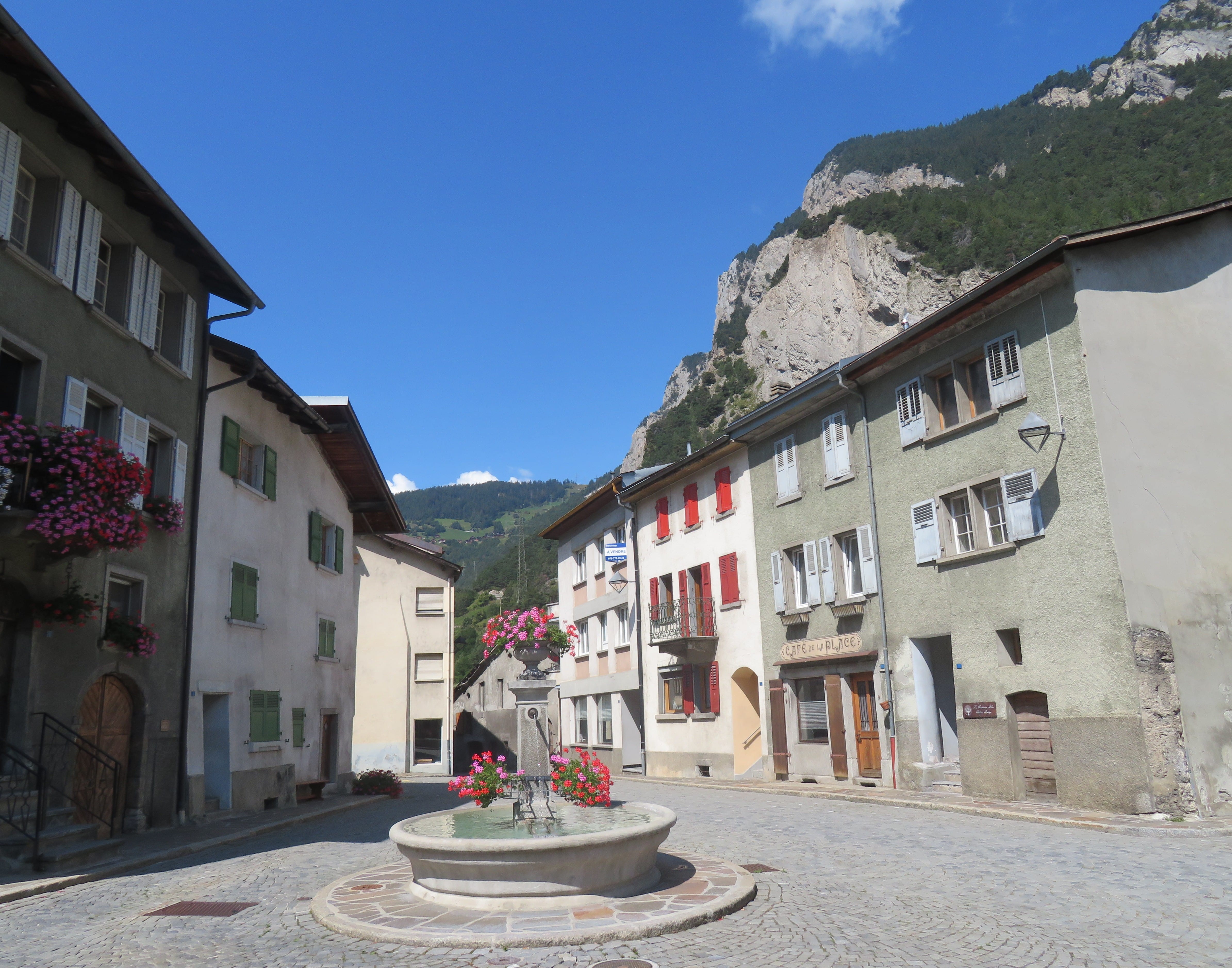 A flower decorated water fountain at the center of Sembrancher